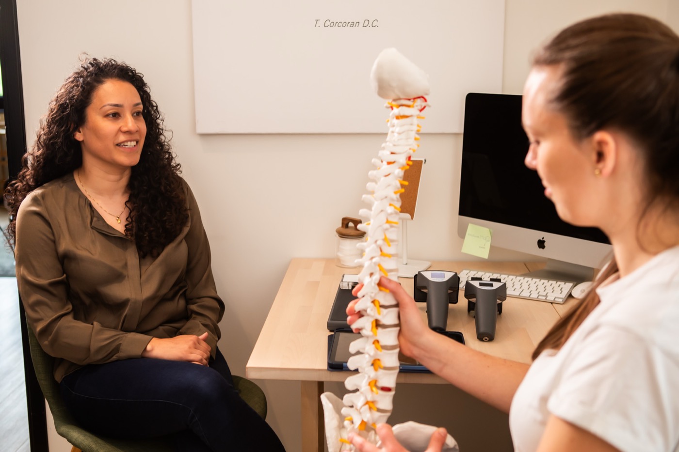 Chiropractor legt met een wervelkolommodel uit wat de scan laat zien bij TOPCHIRO Den Haag
