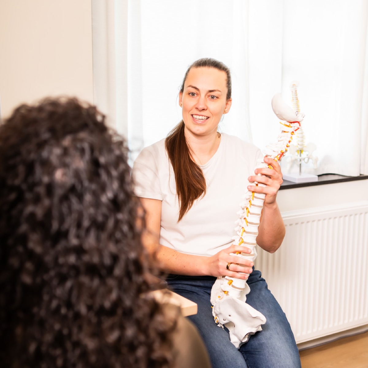 Chiropractor bespreekt het persoonlijke zorgplan met een cliënt bij TOPCHIRO Den Haag
